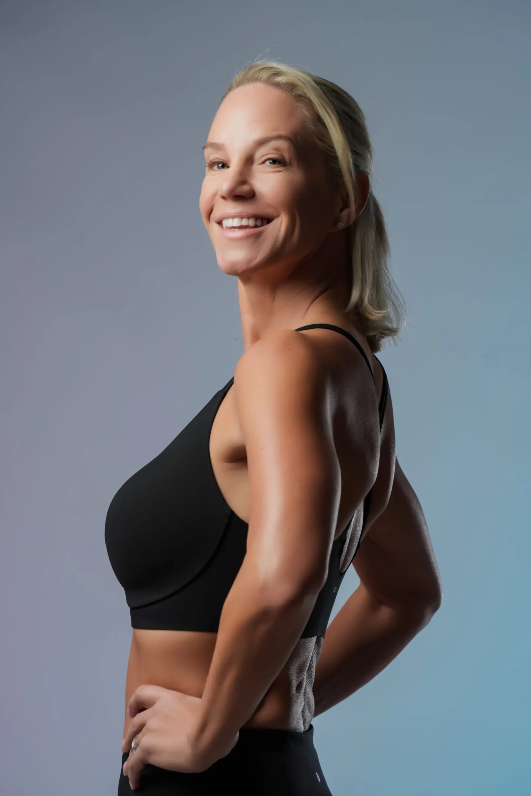 Coach Karina Joyce smiling over her shoulder in a black athletic top